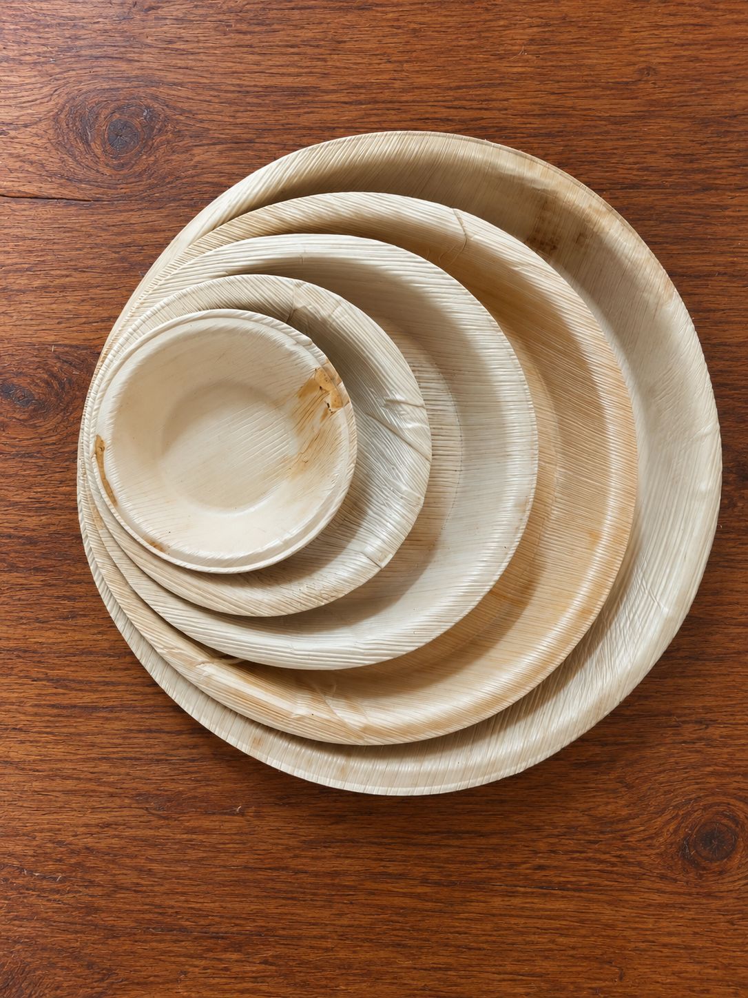 Nested areca leaf plates stacked by size